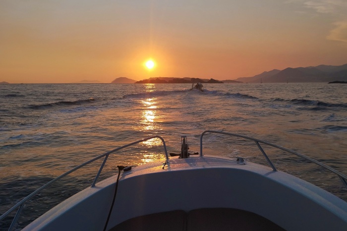 Two persons on the bow of a bow looking at sunset