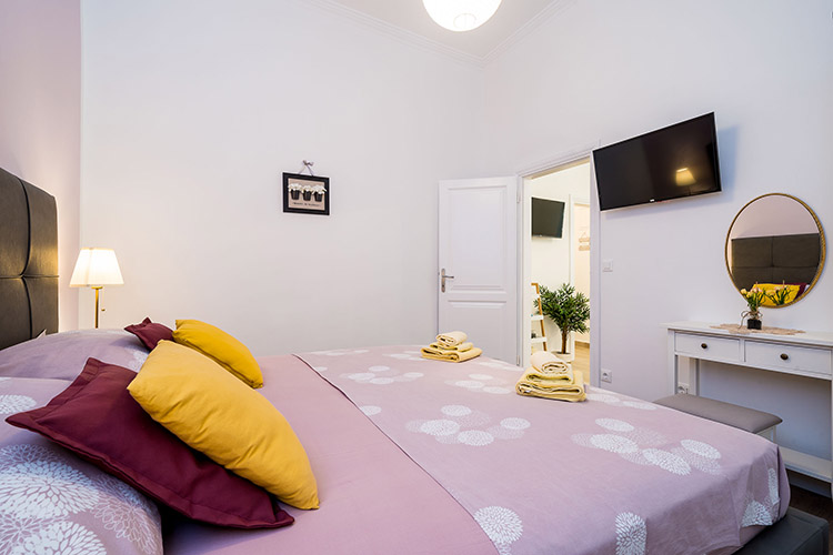 Bedroom towards the entrance with bed and TV